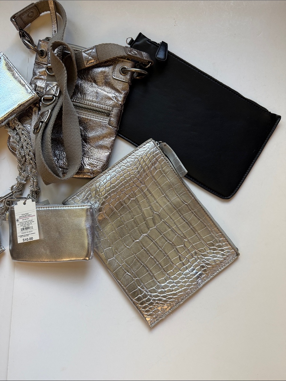 AN ARRAY OF METALLIC CLUTCHES, POUCHES, WALLETS, CROSSBODY….